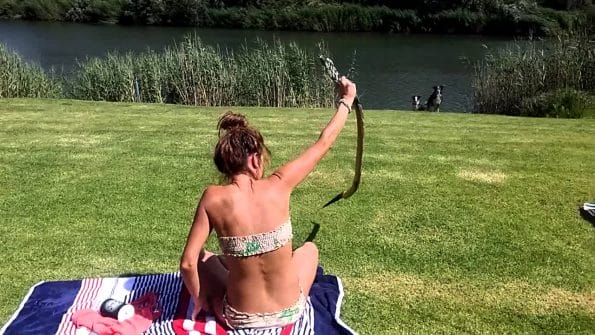 A Girl Catches a Cobra Fearlessly while Taking Sun Bath
