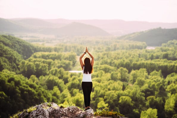 Attractive woman doing yoga. Healthy lifestyle. The concentration of the body. Woman doing yoga in the mountains. Girl doing yoga at sunset. Woman meditates in nature. Meditation in the mountains