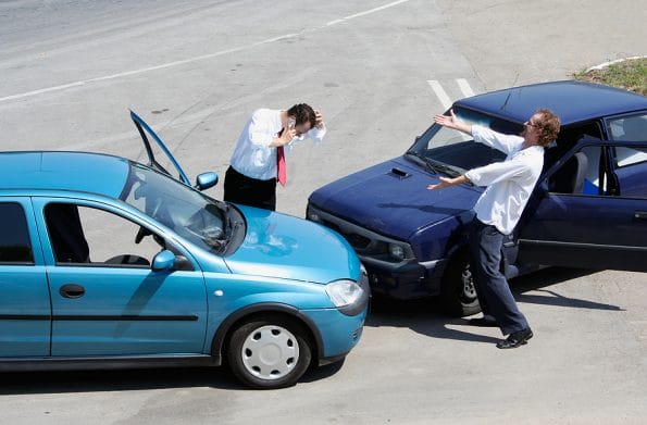 Traffic accident - one driver on the mobile phone second expressing anger