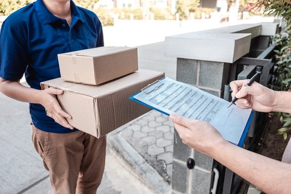 Young Delivery man deliver box parcel package and sending to customer in front of the house, Man customer signing in clipboard form to receive package, shipping delivery concept.