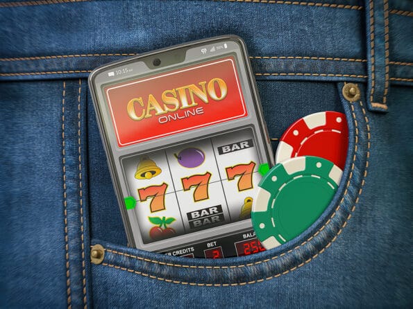 Online casino. Mobile phone or smartphone with slota machine jackpot on the screen in pocket of jeans. 3d illustration