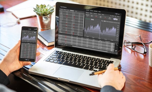 Trade platform, forex trading. Stock exchange market analysis, Man working with a laptop, monitoring app on screen, office desk background. Binary option, candlestick chart.
