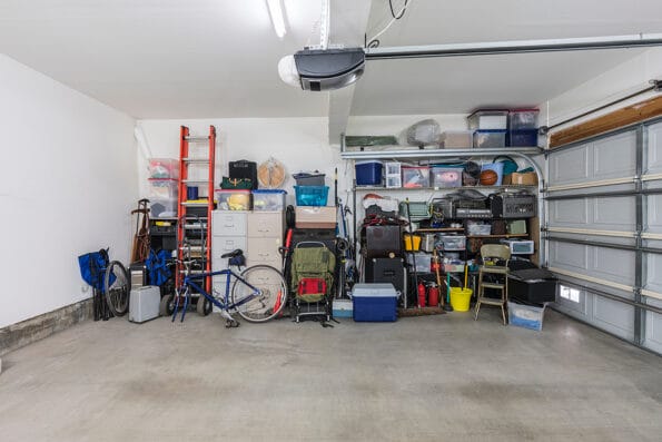 Cluttered but organized clean suburban residential two car garage with tools, file cabinets and sports equipment. organize clutter