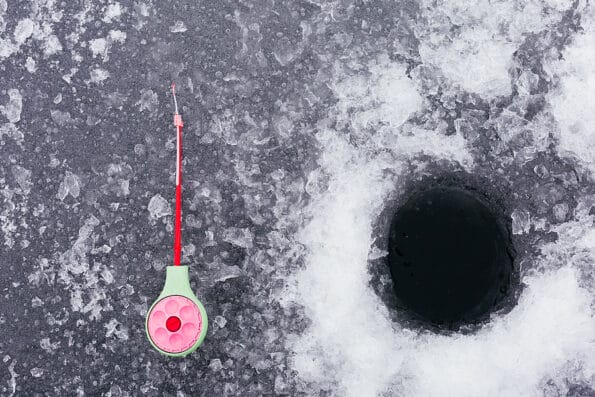 Winter fishing. Fishing rod for ice fishing. Tackle and ice hole. Background. Ice fishing concept crappies