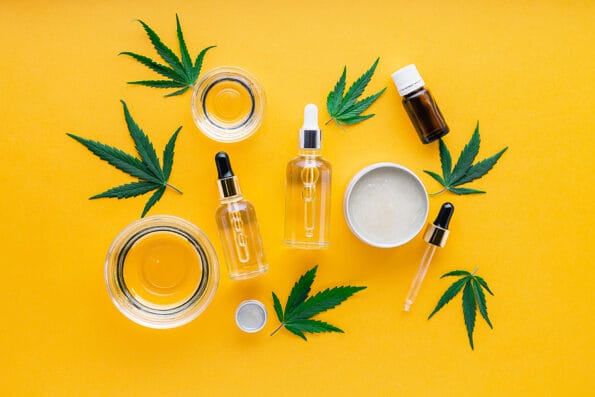 CBD oil, hemp tincture, cannabis cosmetic product for skin care with cannabinoid. Alternative medicine, pharmaceutical medical cannabis. varieties of hemp oil, Serum butter on yellow background