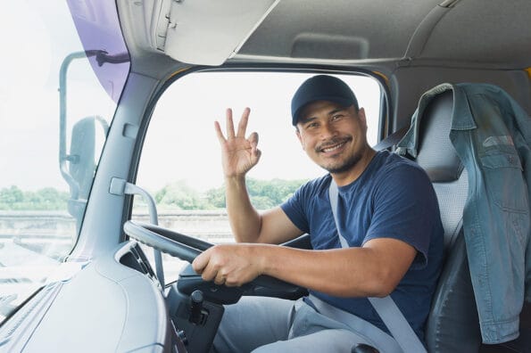 happy smiling proud Confident Asian Young Man beard Professional Truck Driver In Business Long transport. male owner small business transportation trucking driving and delivering goods to warehouse.
