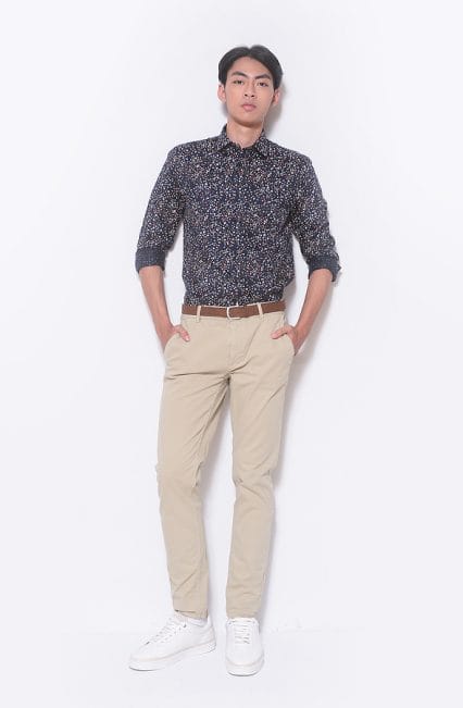 full length handsome casual man wearing fashion shirt with khakis pants and holds pockets standing on white background,