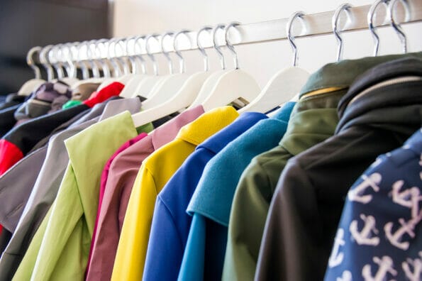 Colorful softshell coats on rack with hangers. Fashion conception.