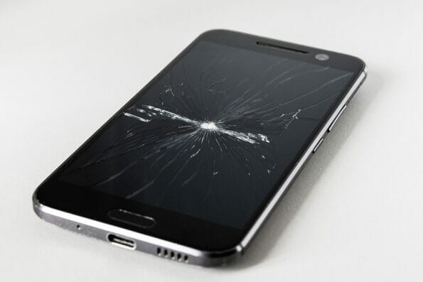 Mobile phone with a broken screen. The display glass of the smartphone is cracked.