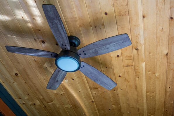 Wooden electric ceiling fan under a timbered ceiling