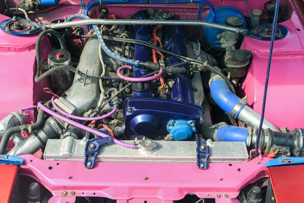 Blue sports car engine, lots of tubes and wires. Under the hood of the drift car