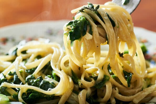 Spinach pasta food on plate.Spinach pasta food on plate.Italian spinach creamy pasta food. Pasta food. Vegetarian pasta food.Spinach tagliatelle pasta.Tagliatelle pasta Food. Creamy spinach pasta food on plate.